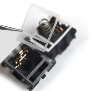 HTV 0.18mm switch film held in tweezers above an open Cherry MX style switch housing